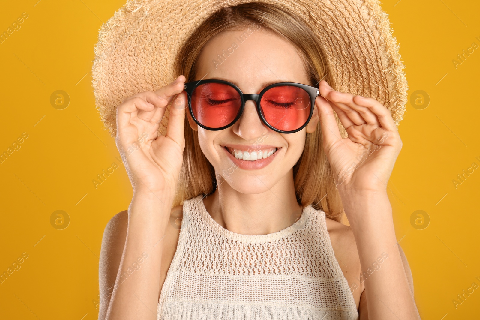 Photo of Beautiful woman in stylish sunglasses on yellow background