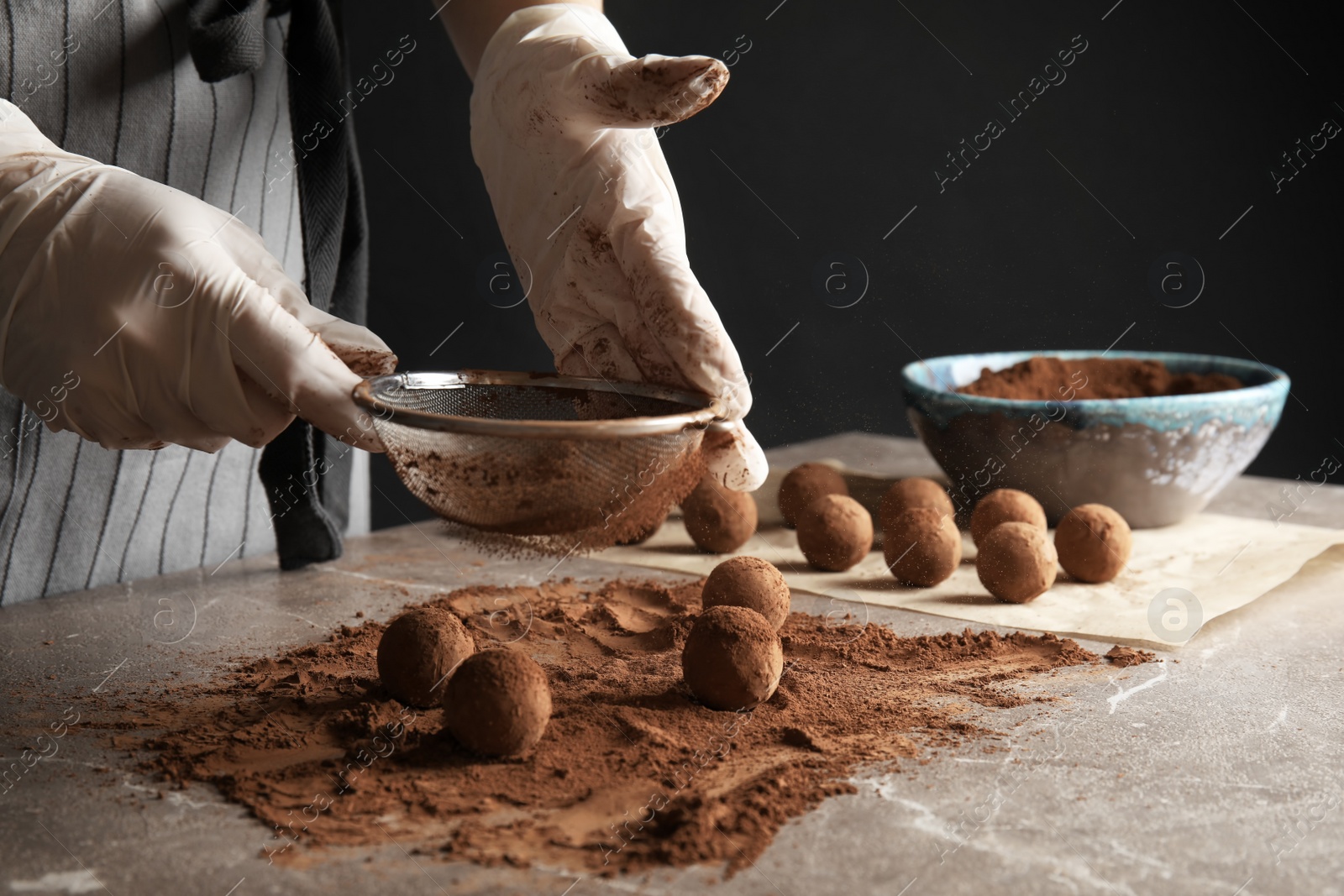 Photo of Woman preparing tasty chocolate truffles at table, closeup