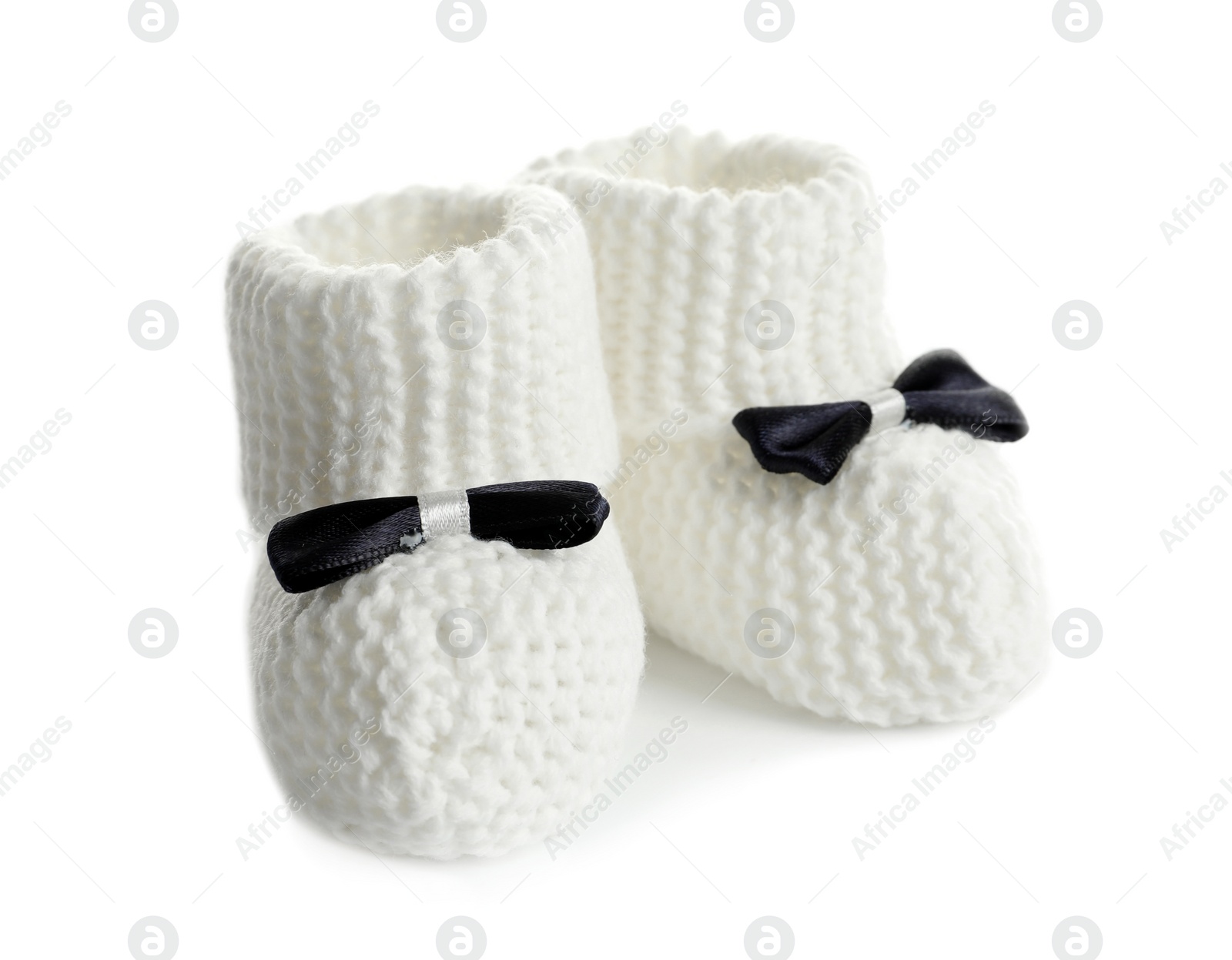 Photo of Handmade baby booties with bows isolated on white