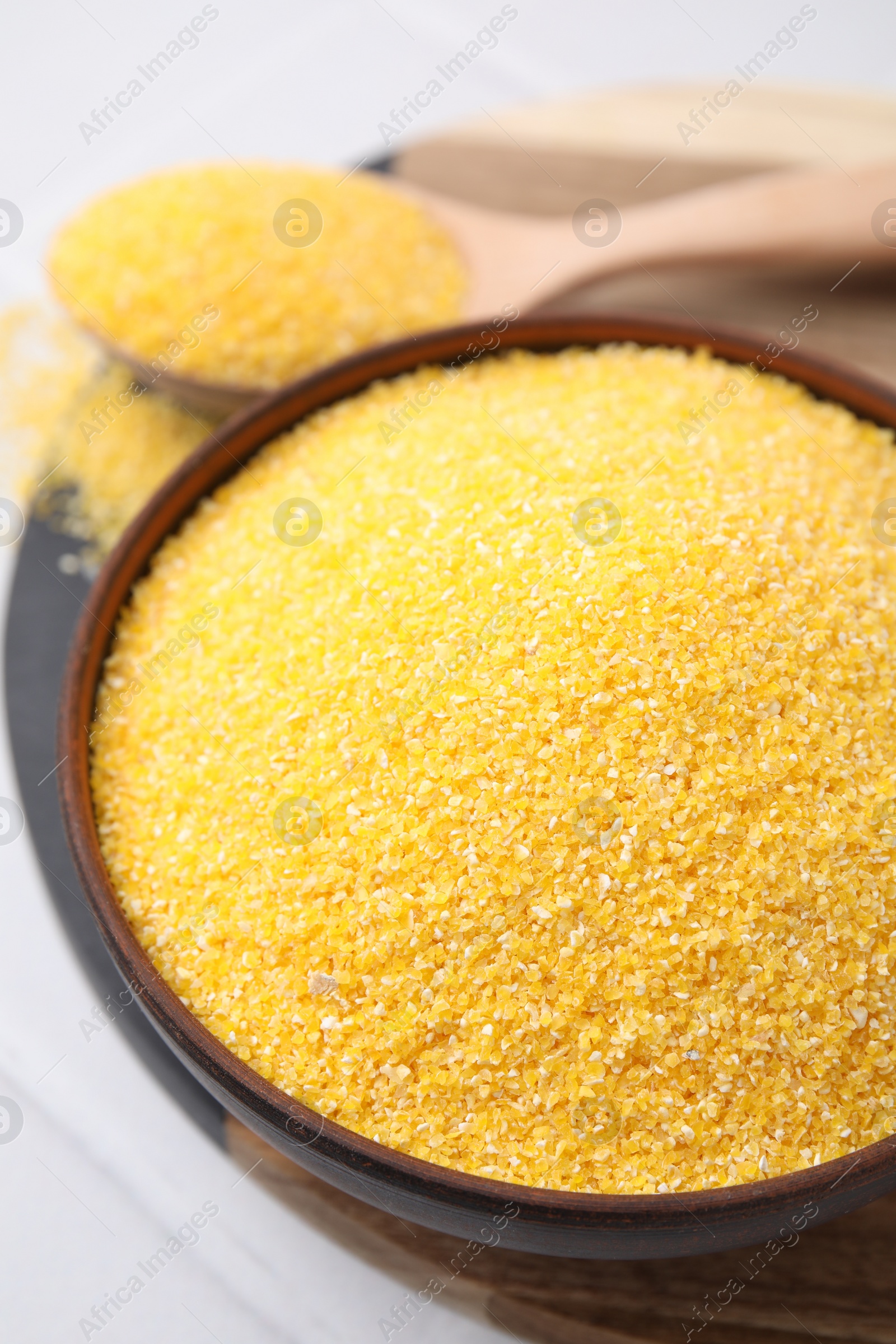 Photo of Raw cornmeal in bowl on white table, above view