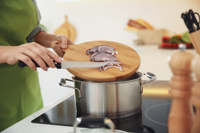 Photo of Woman cooking on stove in kitchen, closeup