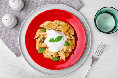 Flat lay composition with tasty pasta on white wooden table