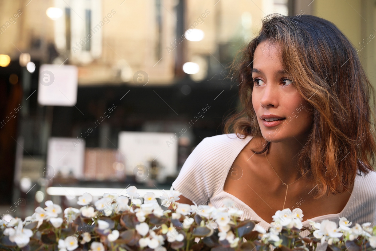 Photo of Portrait of beautiful young woman near flowers outdoors