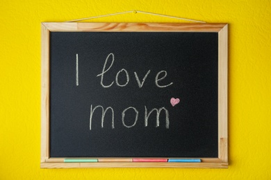 Photo of Blackboard with written text I LOVE MOM on color background