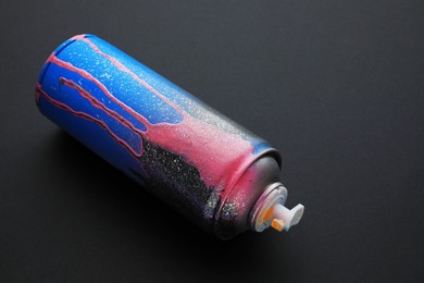 Photo of Used can of spray paint on black background. Graffiti supply