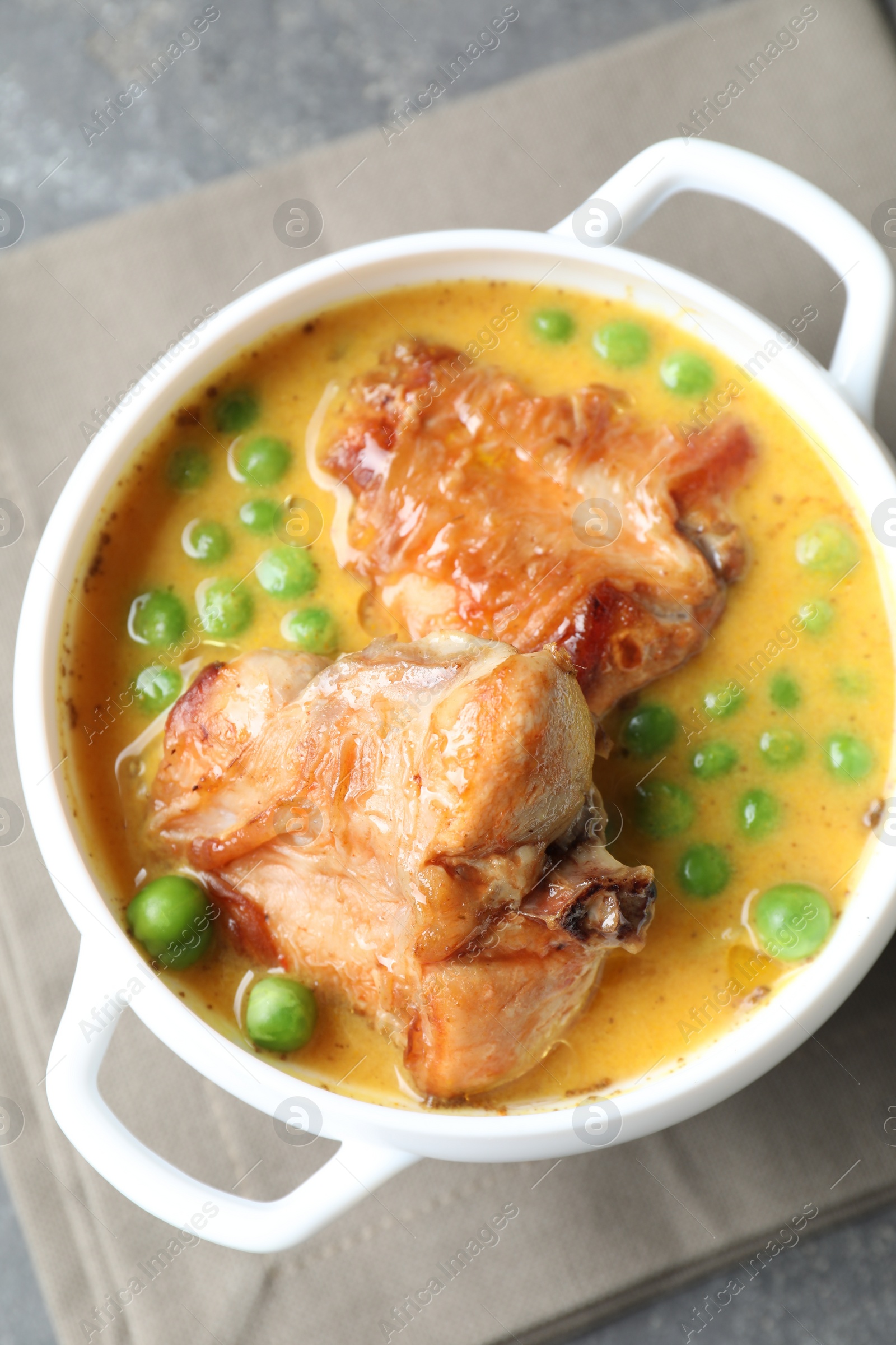 Photo of Tasty cooked rabbit meat with sauce and peas on table, top view