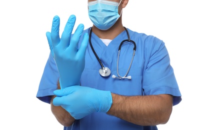Photo of Doctor in protective mask putting on medical gloves against white background, closeup