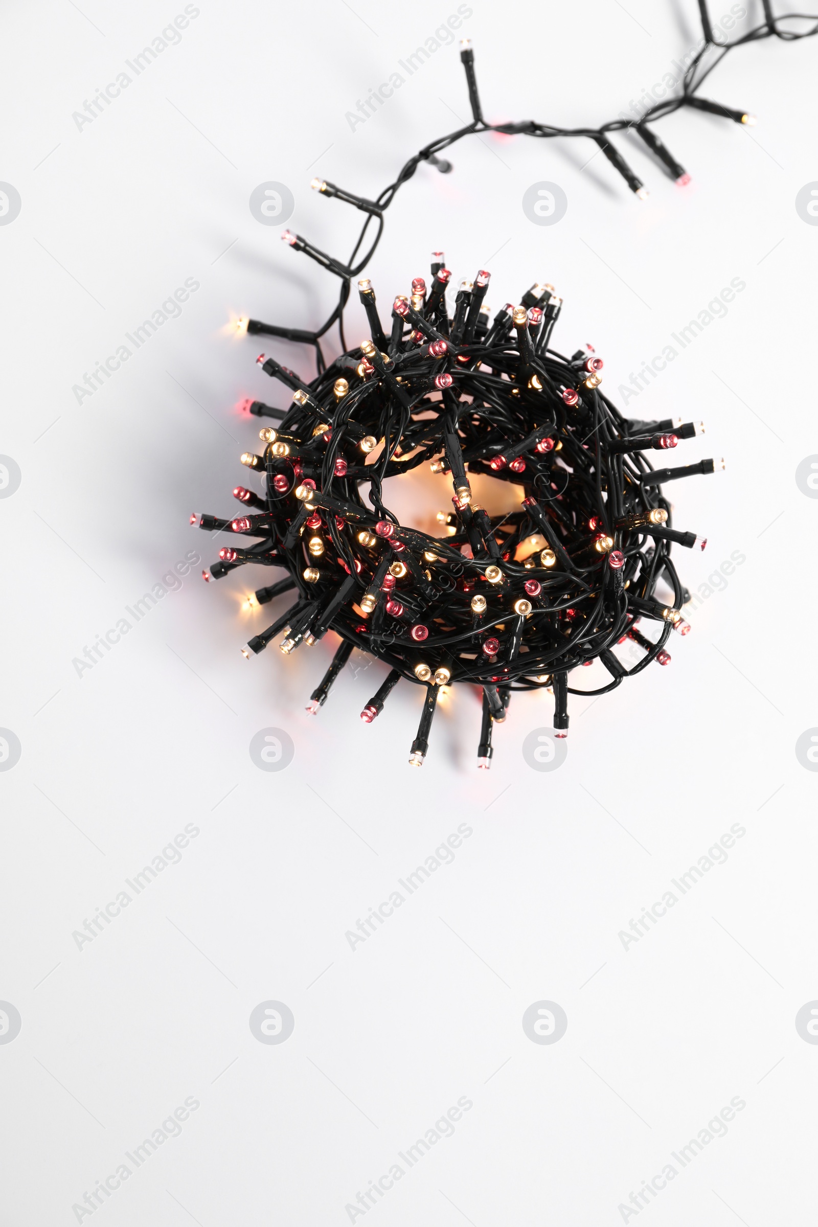 Photo of Beautiful Christmas lights on white background, top view