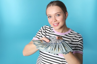 Photo of Portrait of happy young woman with money on color background