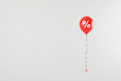 Image of Discount offer. Red balloon with percent sign on white background, space for text