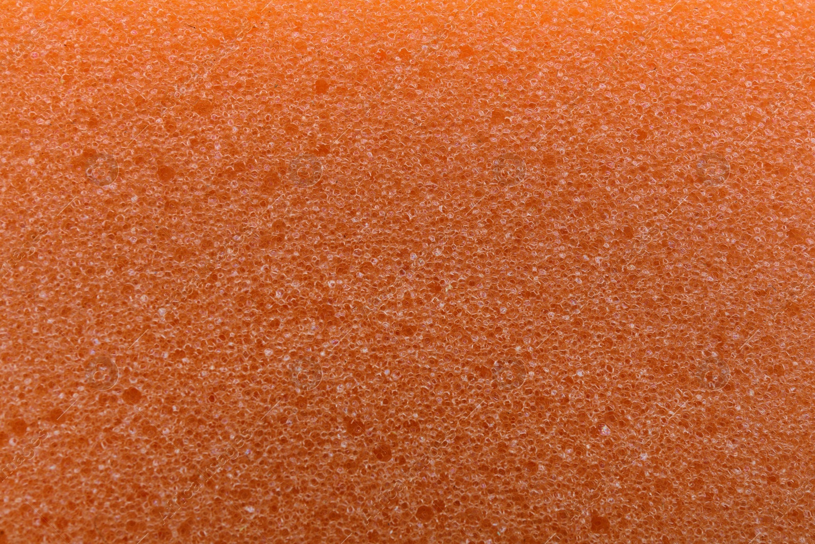 Photo of Orange cleaning sponge as background, top view