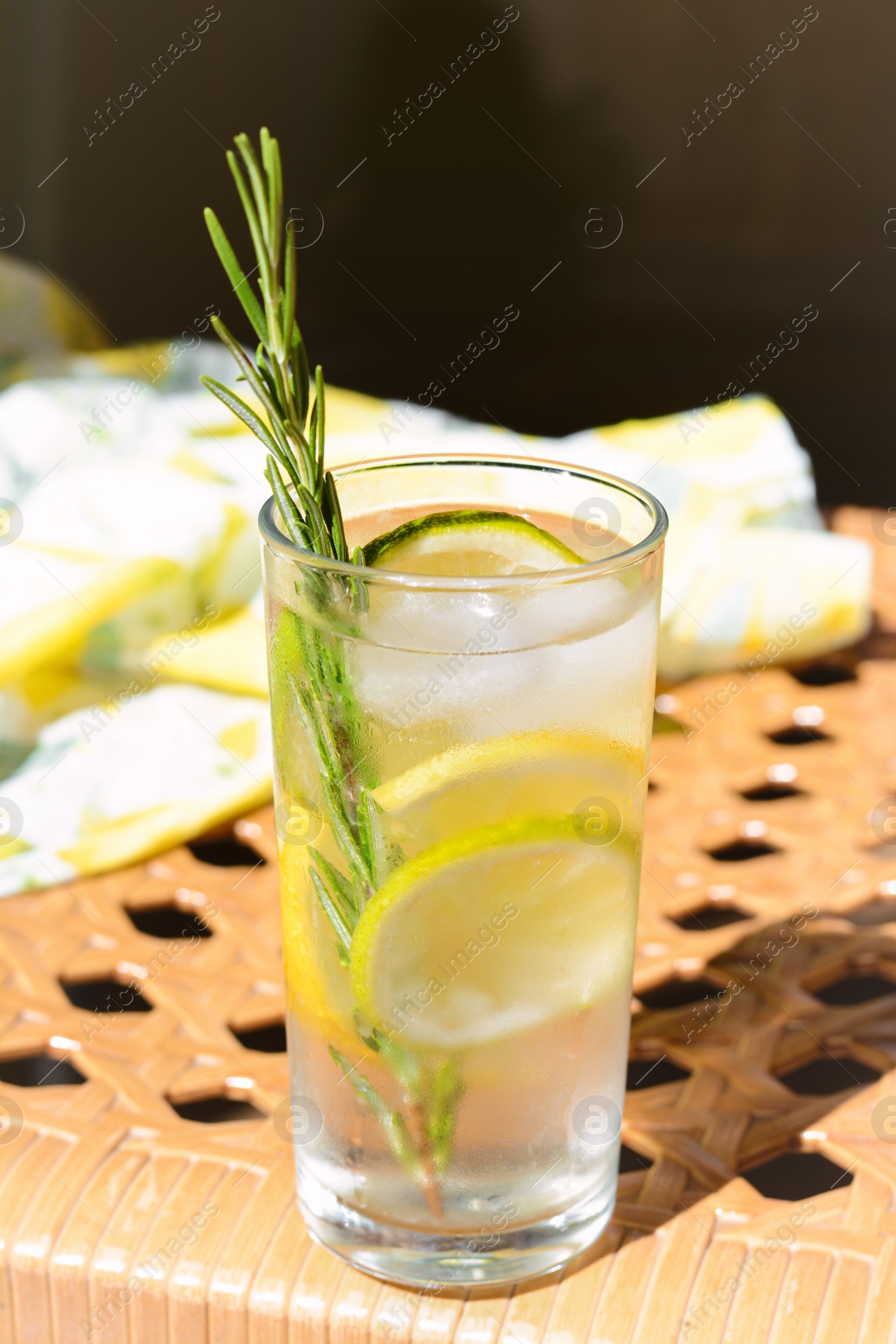 Photo of Tasty refreshing lemonade on wicker bench. Summer drink