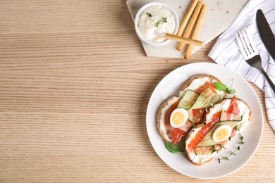 Delicious bruschettas with salmon served on wooden table, flat lay. Space for text