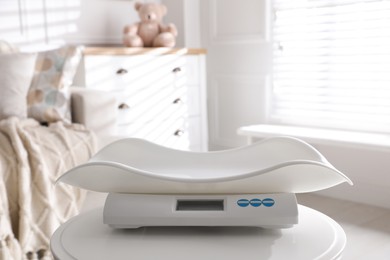 Modern digital baby scales on table in room