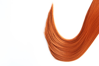 Beautiful strand of straight red hair on white background, top view. Hairdresser service