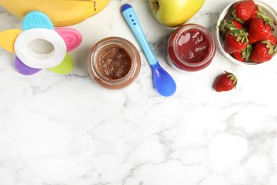 Healthy baby food in jars and fresh ingredients on white marble table, flat lay. Space for text