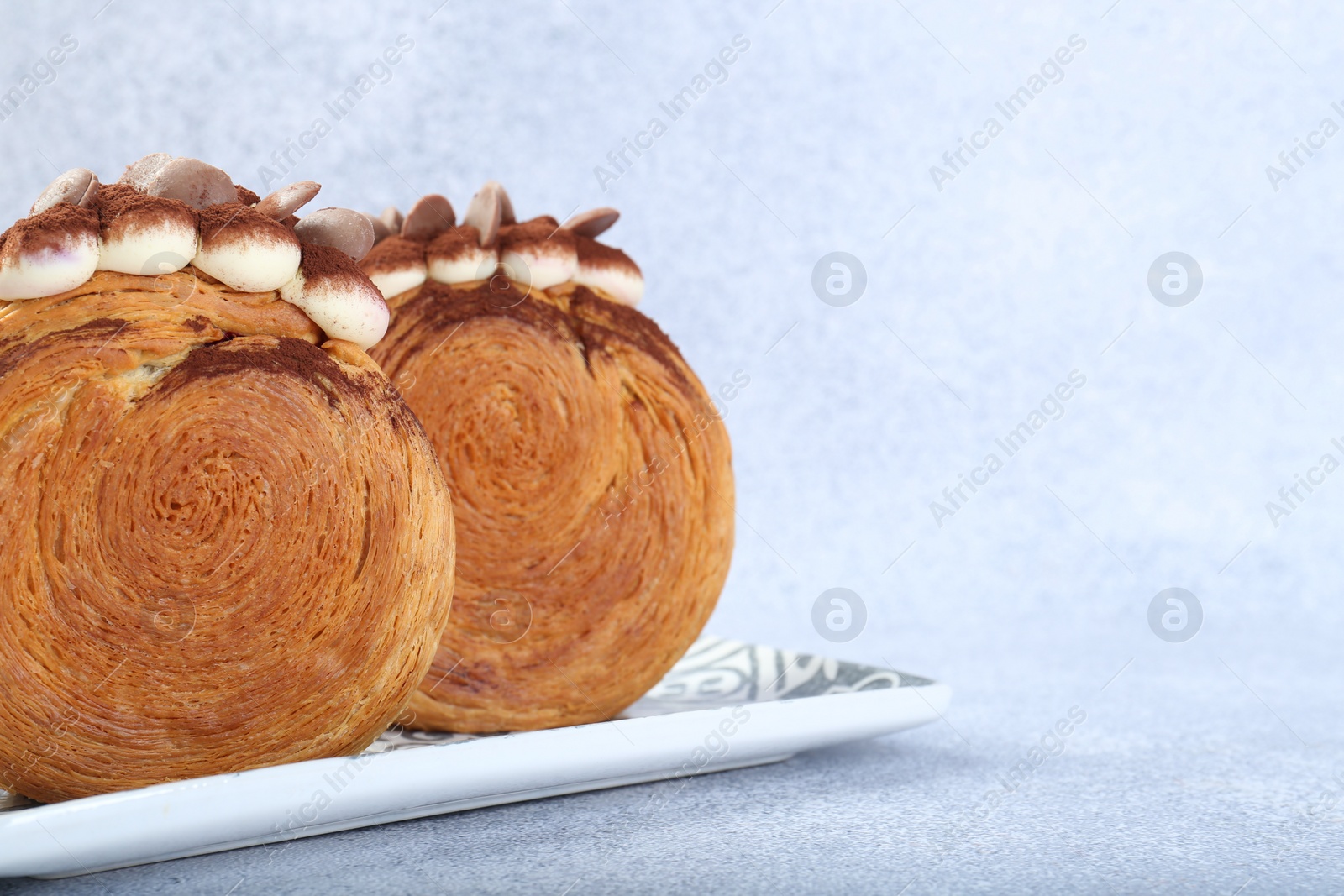 Photo of Tasty puff pastry. Supreme croissants with chocolate chips and cream on grey background, closeup. Space for text