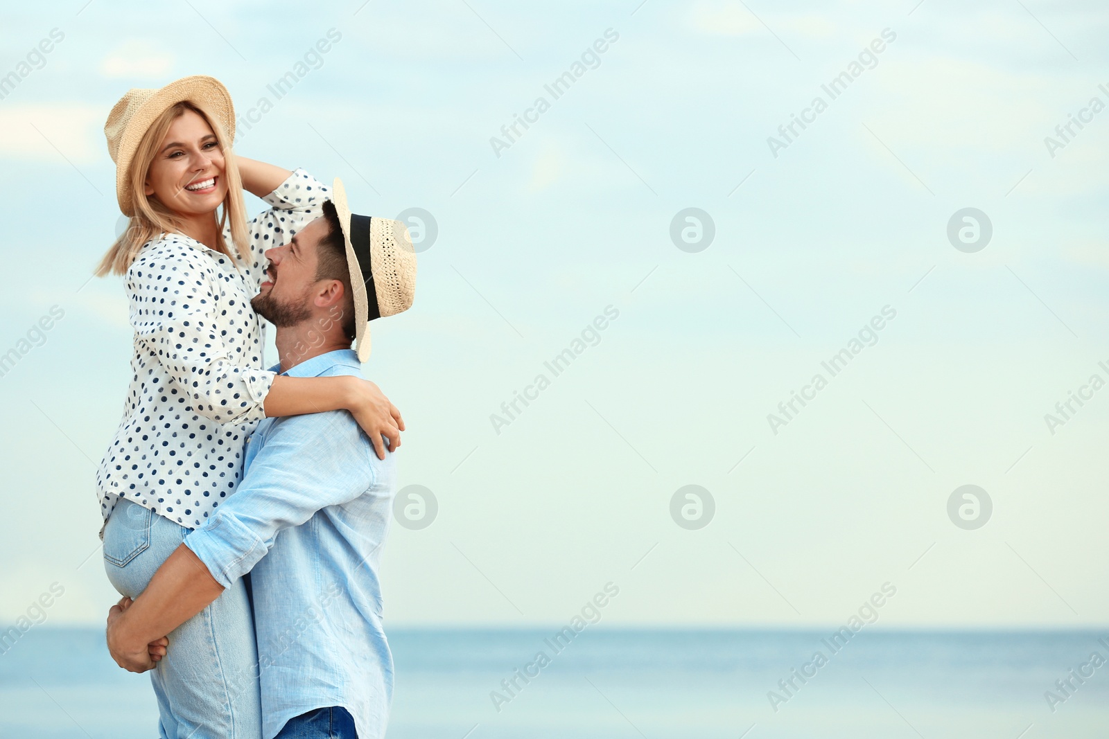 Photo of Happy romantic couple spending time together on beach, space for text