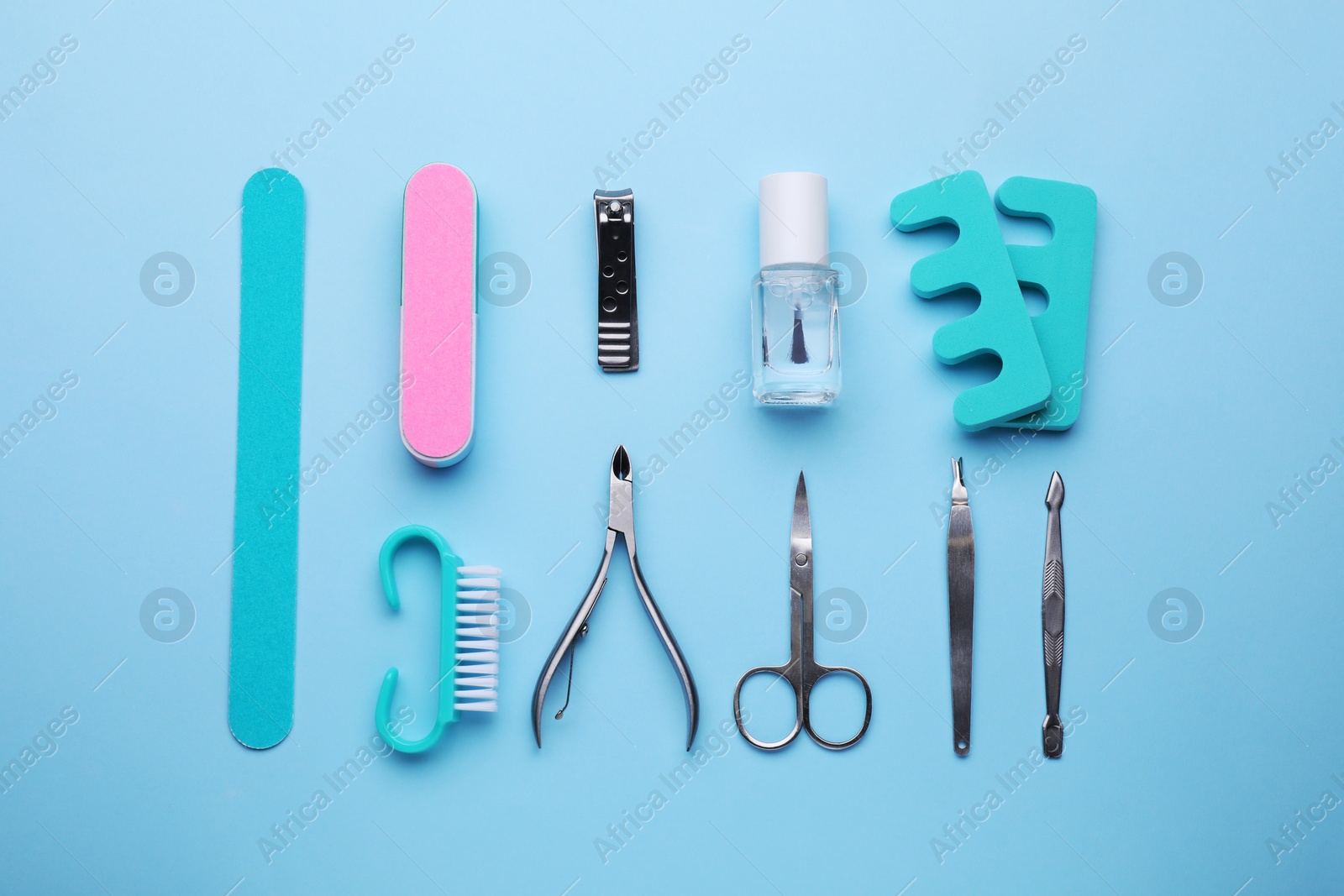 Photo of Set of pedicure tools on light blue background, flat lay