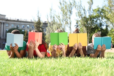 Photo of Group of children with books outdoors. Summer camp