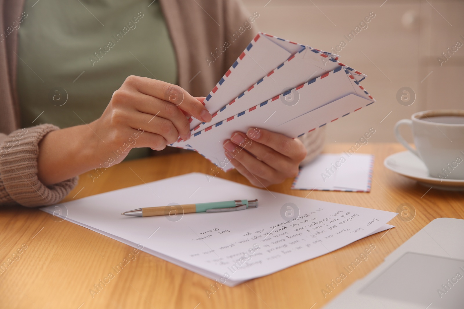 Photo of Woman with letter at wooden table indoors, closeup