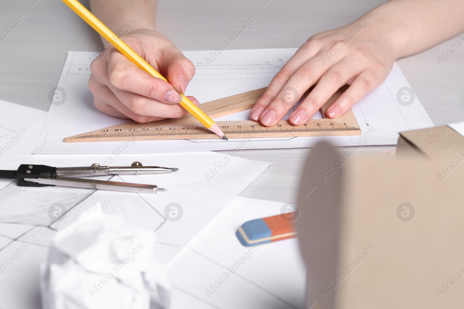 Photo of Woman creating packaging design at light wooden table, closeup