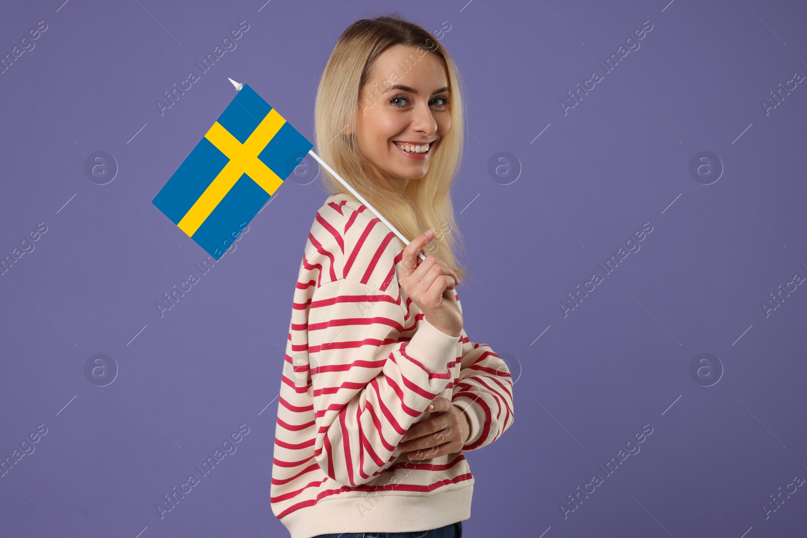 Image of Happy young woman with flag of Sweden on purple background