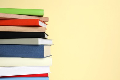 Photo of Stack of different books on beige background, space for text