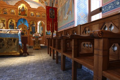 Photo of Beautiful view of empty wooden benches near window in church