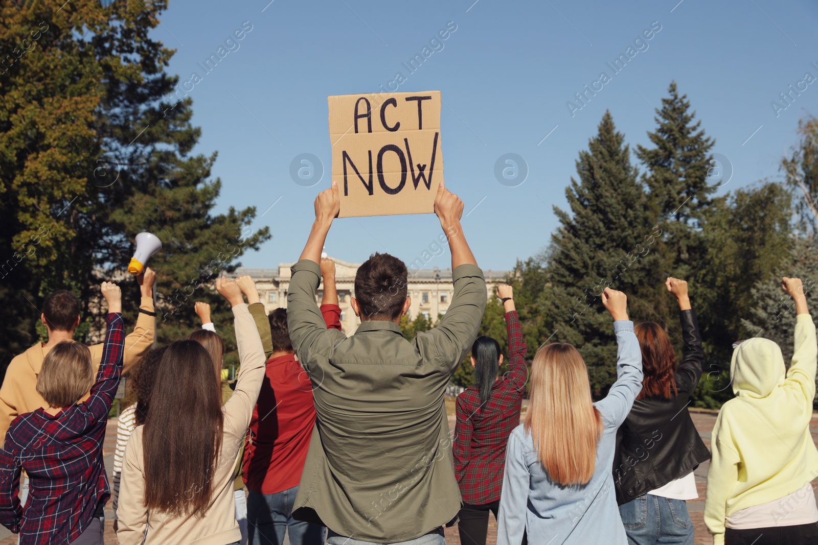 Photo of Group of people with posters protesting against climate change outdoors, back view