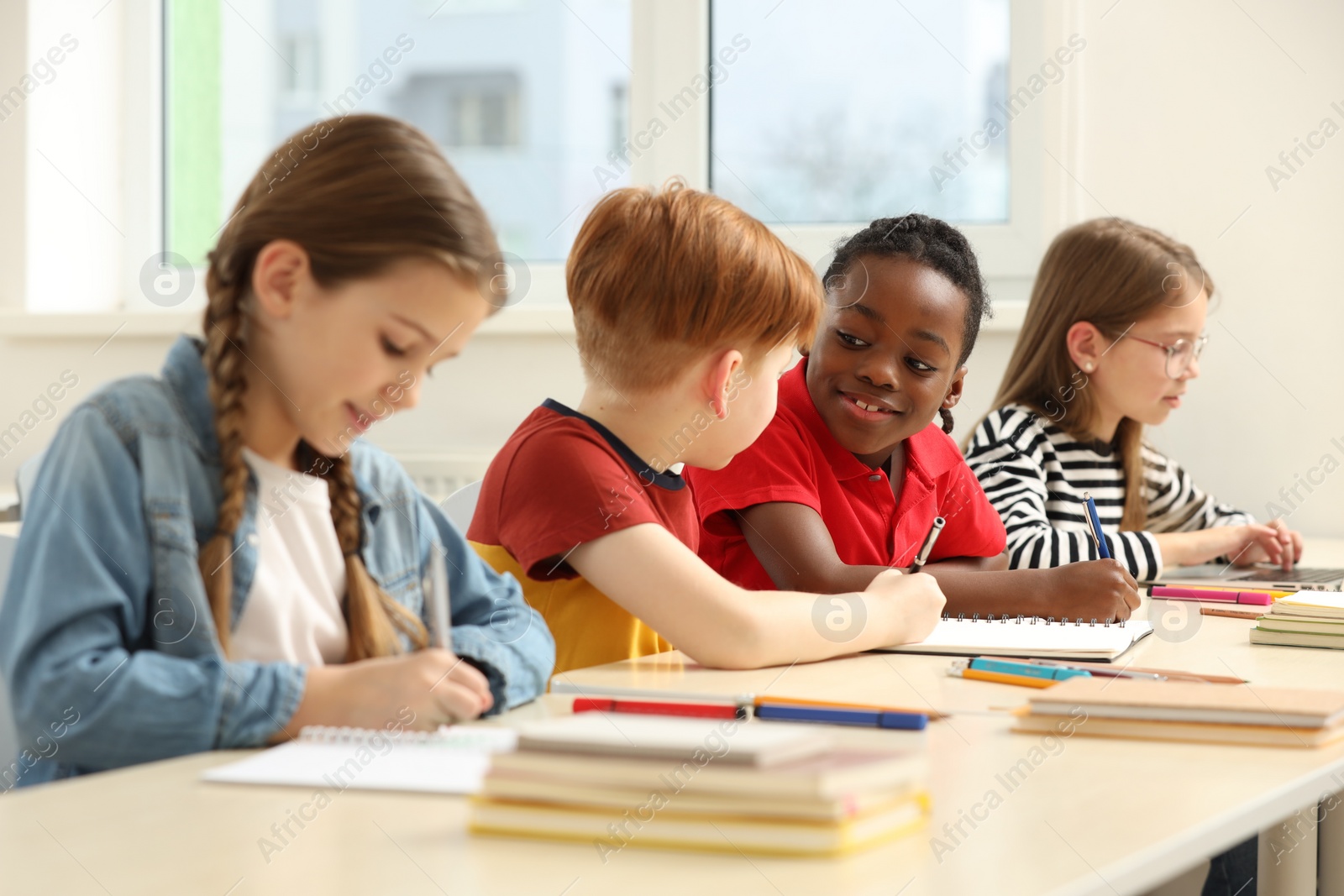 Photo of Cute children studying in classroom at school