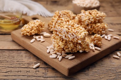 Photo of Board with puffed rice pieces (kozinaki) on wooden table, space for text