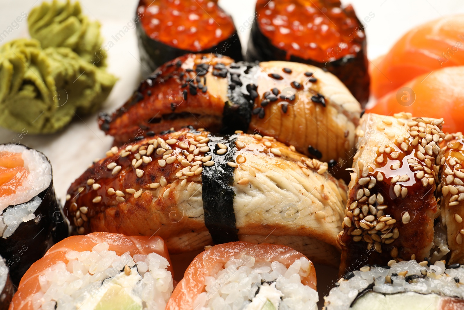 Photo of Set of delicious sushi rolls and wasabi, closeup view