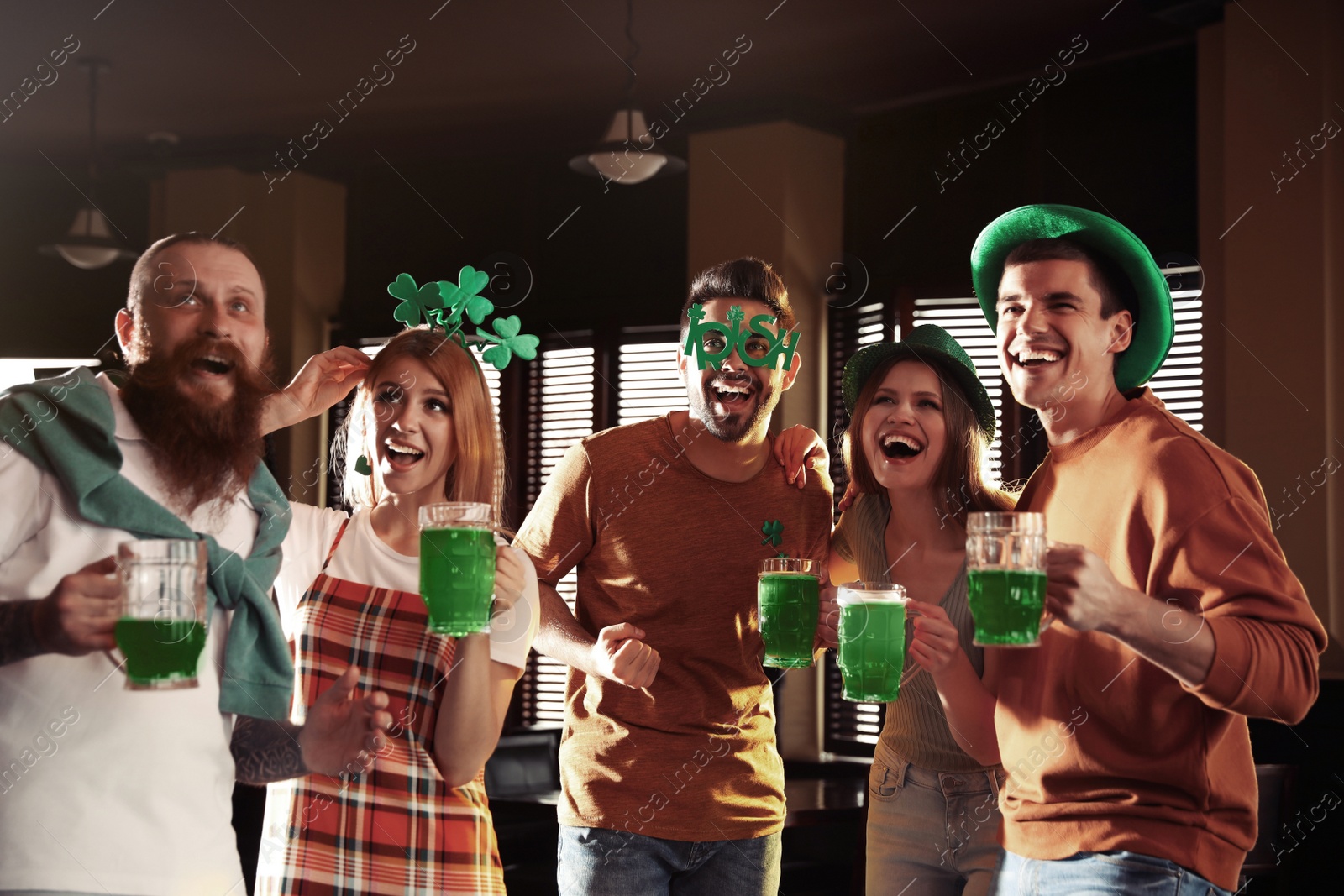 Photo of Group of friends with glasses of green beer in pub. St. Patrick's Day celebration