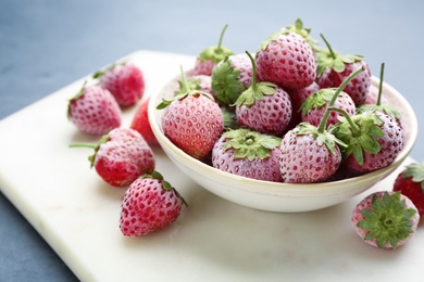 Photo of Tasty frozen strawberries on white board, closeup