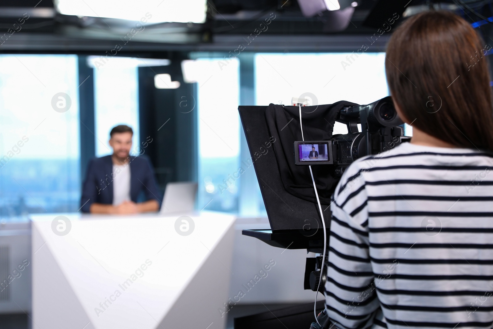 Photo of Professional video camera operator working in studio. News broadcasting