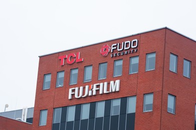Photo of Warsaw, Poland - September 10, 2022: Building with modern TCL, Fudo Security and Fujifilm logos