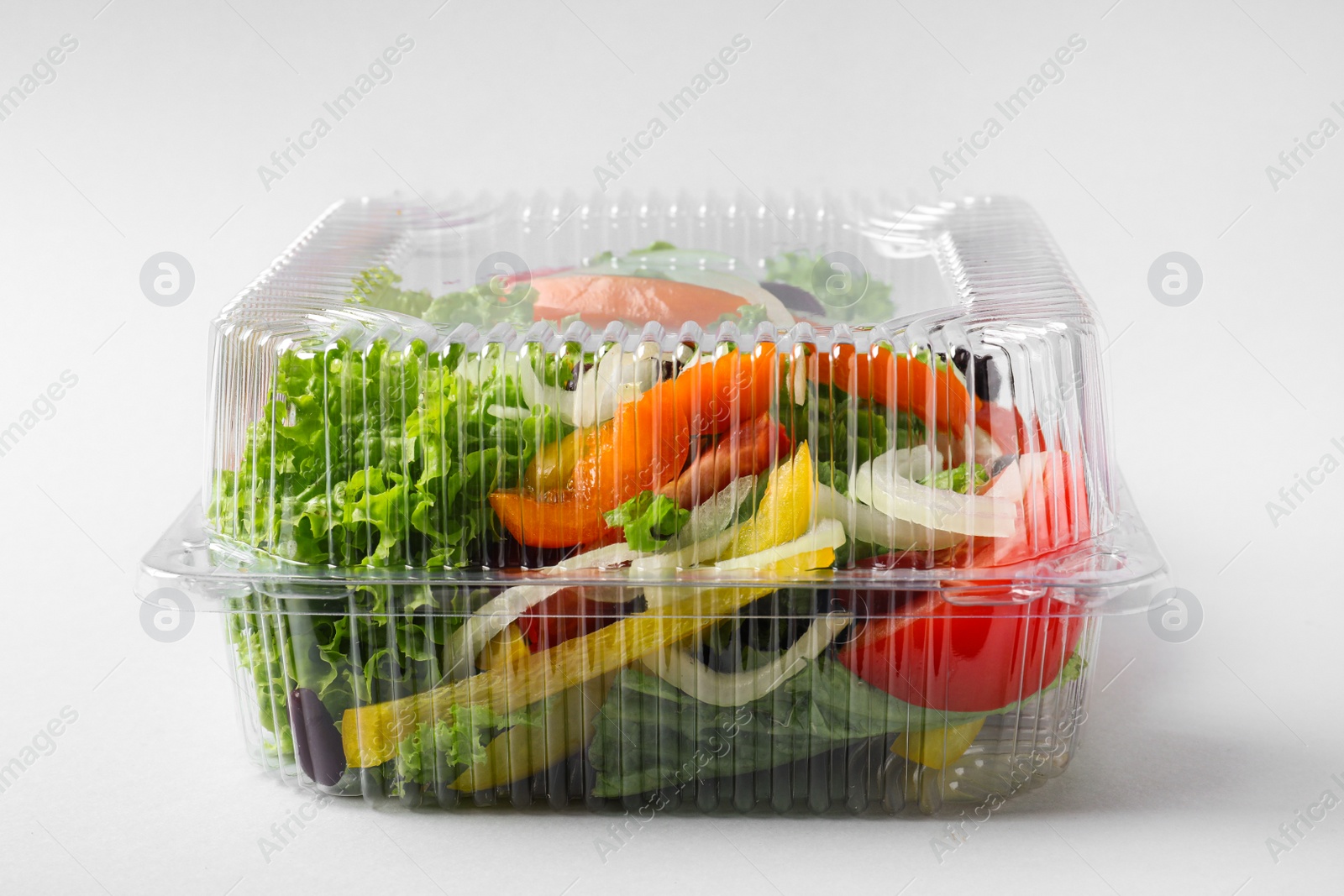 Photo of Plastic container with fresh salad on light grey background