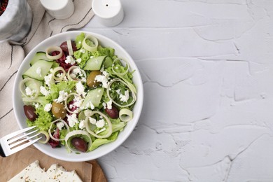 Photo of Bowl of tasty salad with leek, olives and cheese on white textured table, flat lay. Space for text