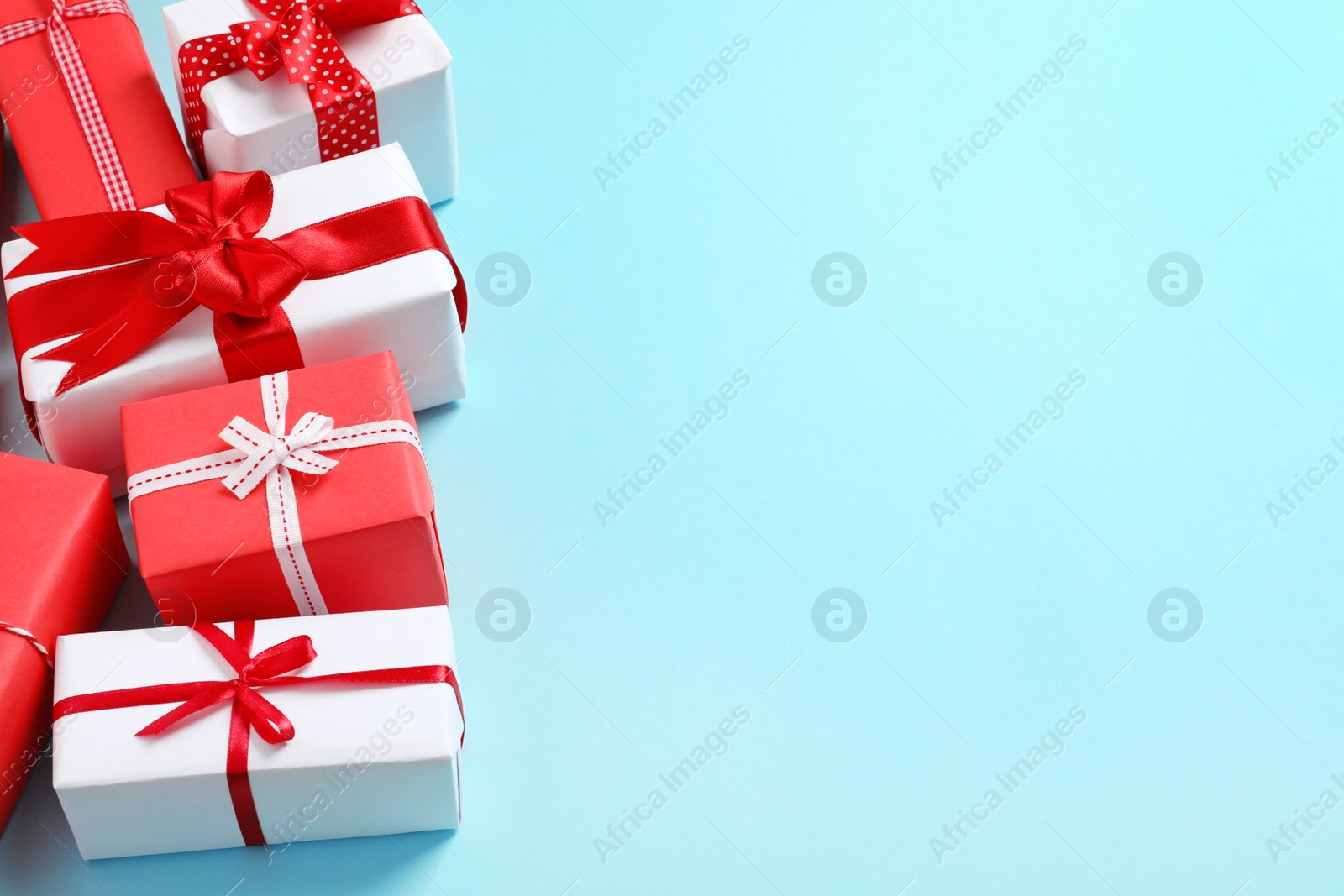 Photo of Beautifully wrapped gift boxes on color background