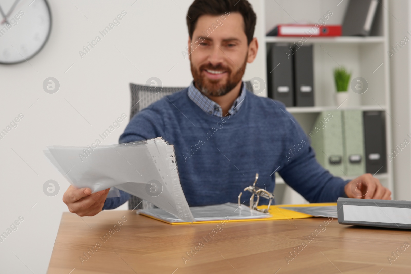 Photo of Businessman with punched pockets at wooden table in office, selective focus