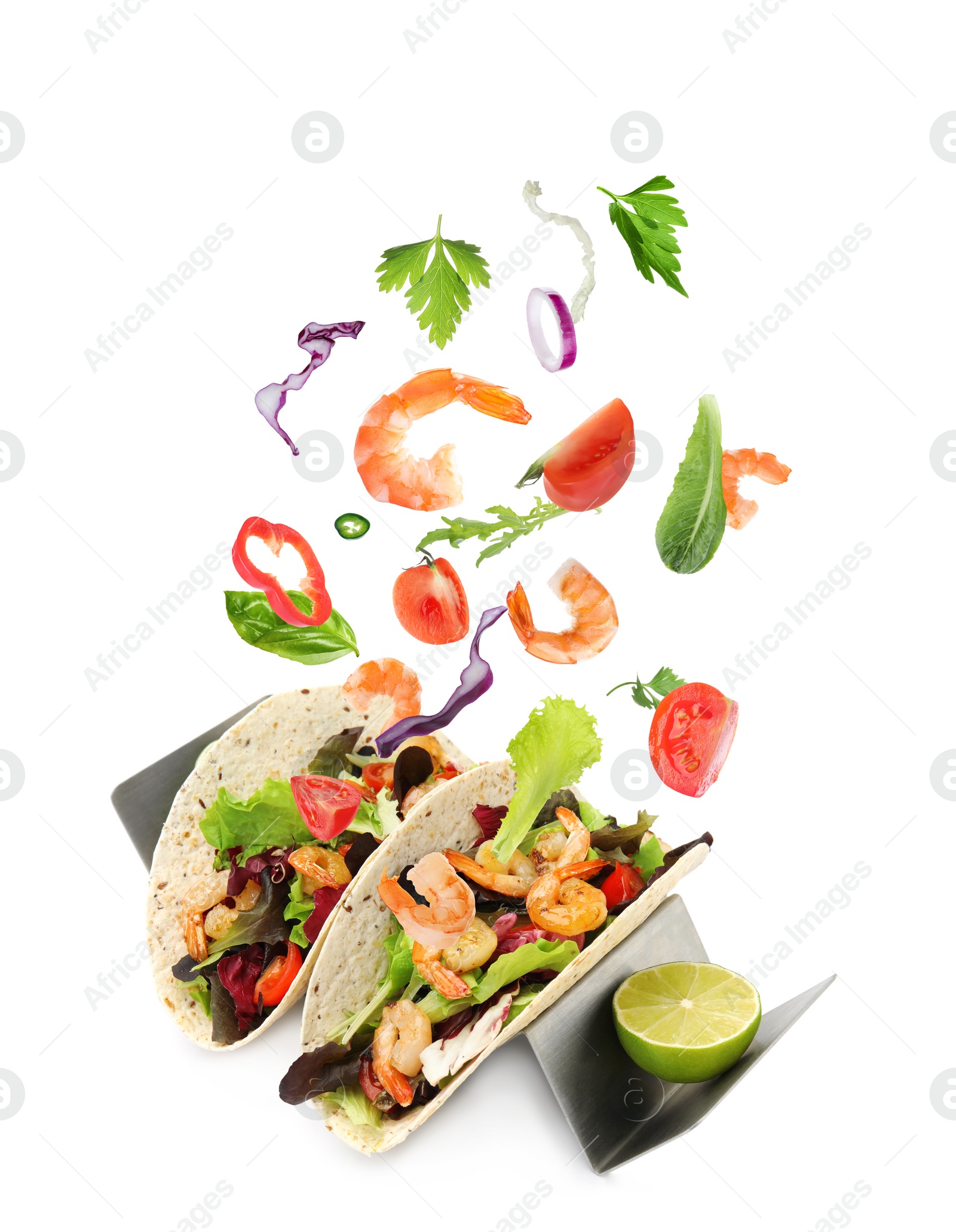 Image of Delicious tacos. Ingredients falling into tortillas on white background