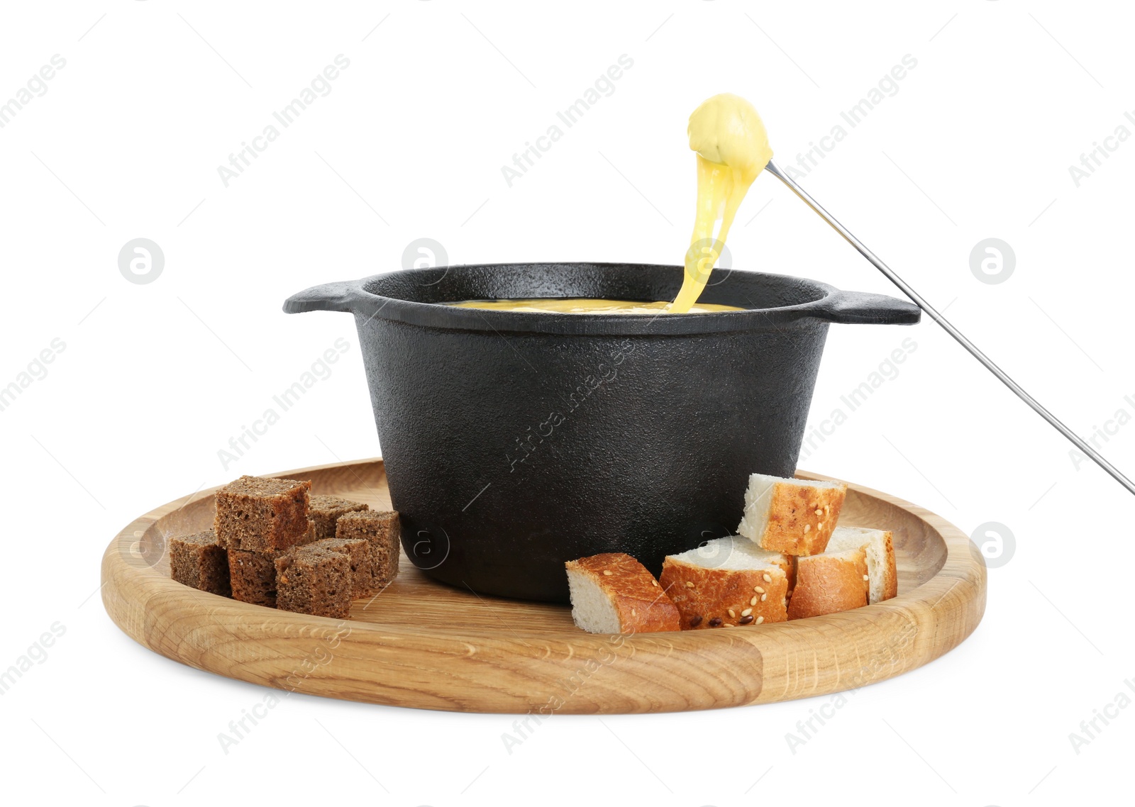 Photo of Dipping piece of bread into fondue pot with tasty melted cheese isolated on white