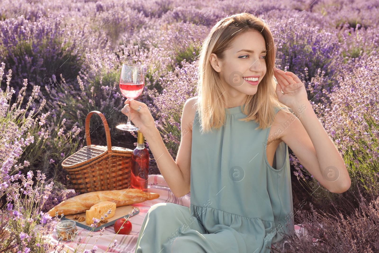 Photo of Young woman having picnic in lavender field