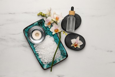 Flat lay composition with different spa products and flowers on white marble table