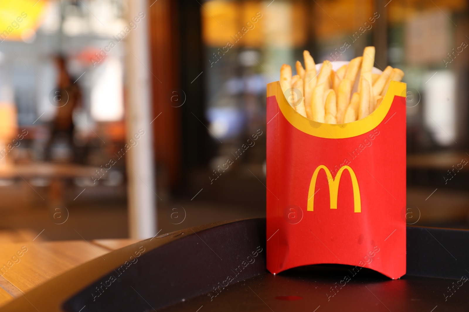 Photo of MYKOLAIV, UKRAINE - AUGUST 11, 2021: Big portion of McDonald's French fries on tray in cafe. Space for text