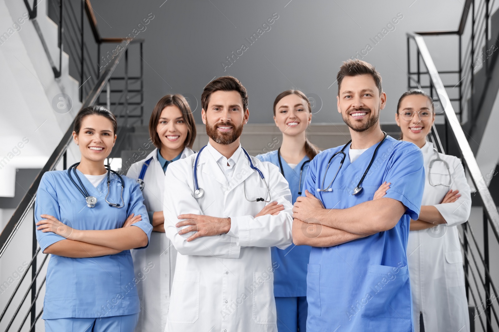 Photo of Team of professional doctors on staircase in clinic