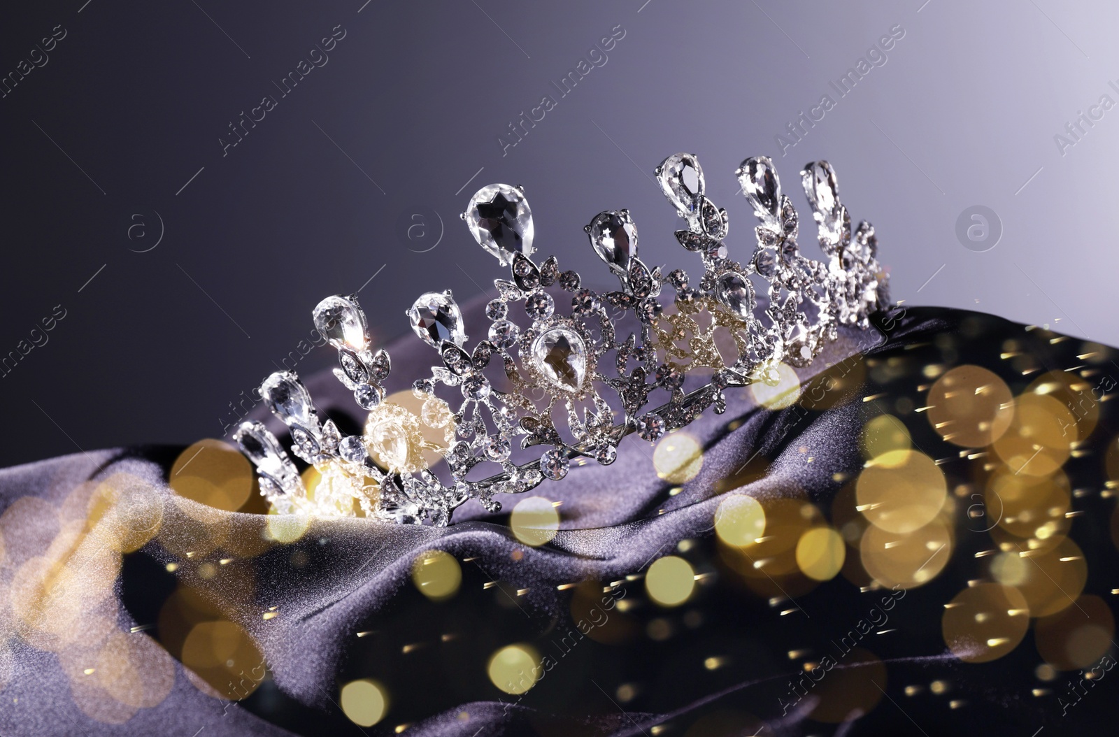 Image of Beautiful silver tiara with diamonds on dark cloth, bokeh effect