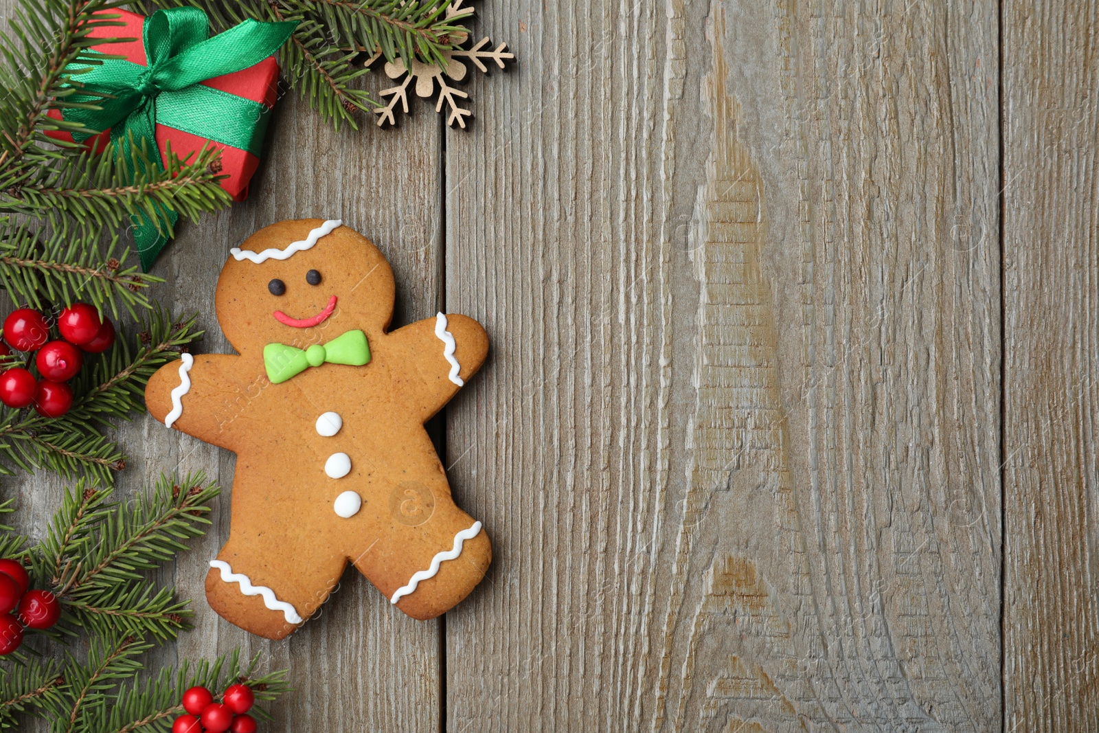 Photo of Flat lay composition with gingerbread man on wooden table, space for text