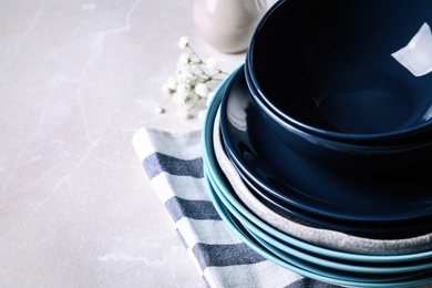 Different dishware on light grey marble table, space for text